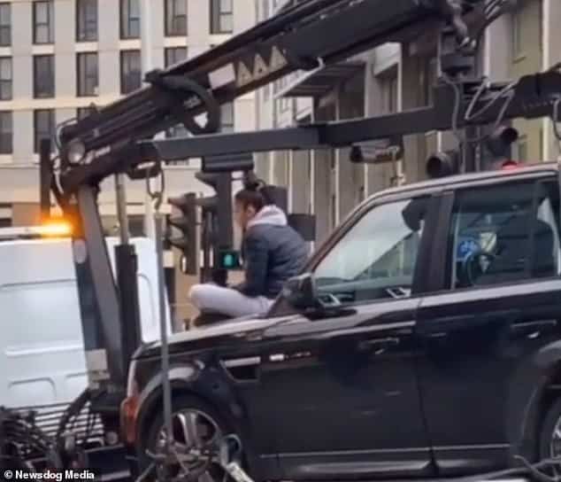 Range Rover driver defiantly sits on her car bonnet in a bid to stop ...
